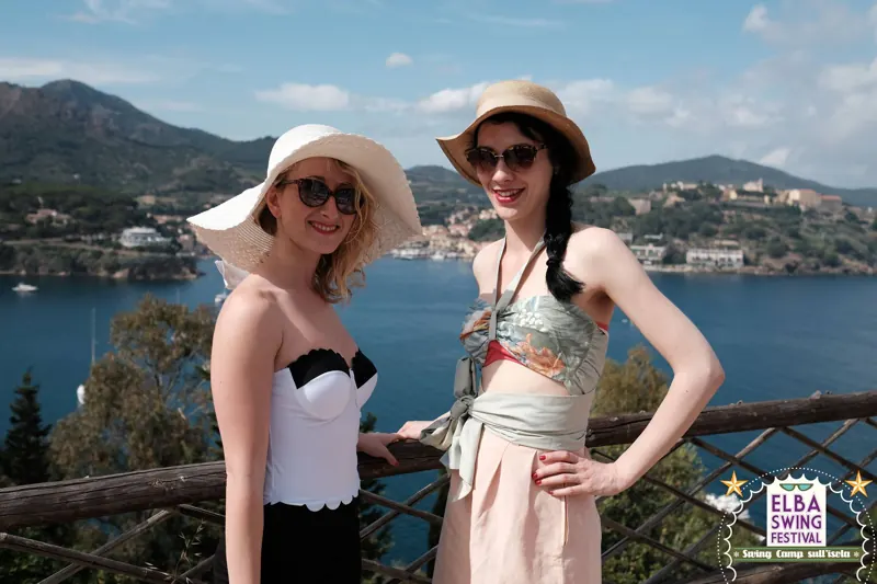 Due ragazze in costume vintage con il golfo alle spalle
